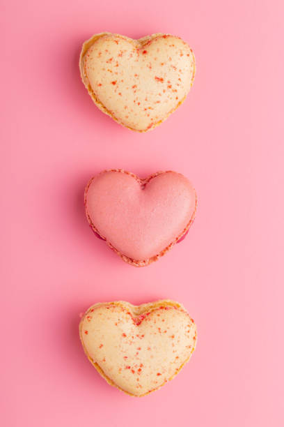 istock Heart shaped Sweet macarons on pink background. 1400060315