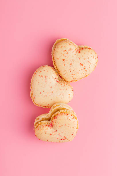 istock Heart shaped Sweet macarons on pink background. 1400060316
