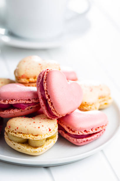istock Heart shaped Sweet macarons on white table. 1400060318
