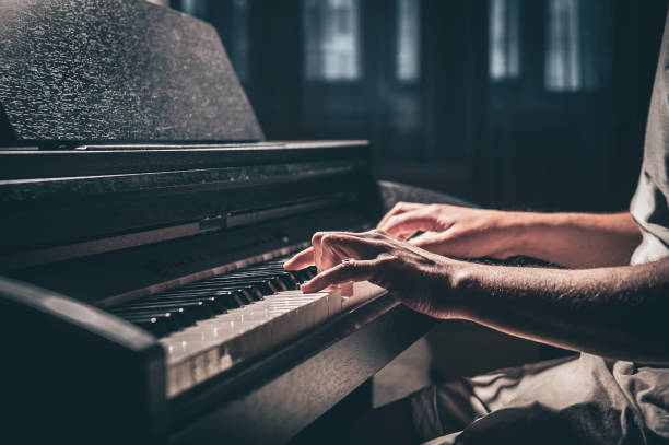 istock A man plays an electronic piano in a dark room. 1400060368