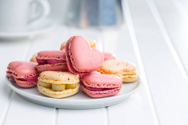 istock Heart shaped Sweet macarons on white table. 1400060375
