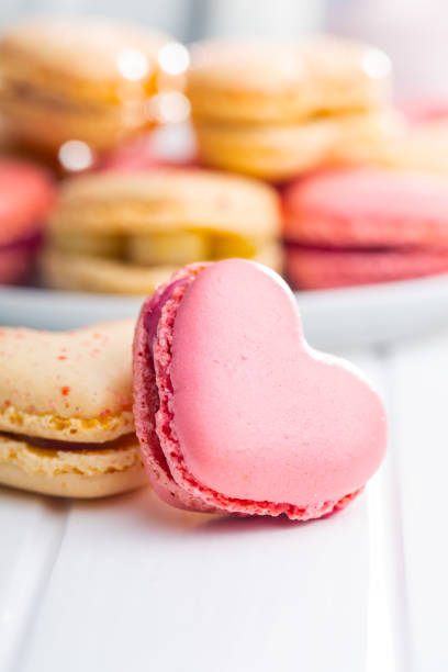 istock Heart shaped Sweet macarons on white table. 1400060377