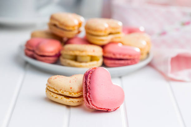 istock Heart shaped Sweet macarons on white table. 1400060386