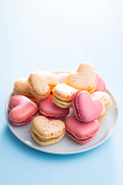 istock Heart shaped Sweet macarons on blue table. 1400060387
