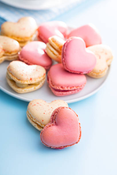 istock Heart shaped Sweet macarons on blue table. 1400060419