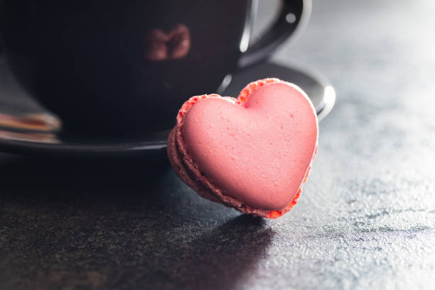 istock Heart shaped Sweet macarons on black table. 1400060450