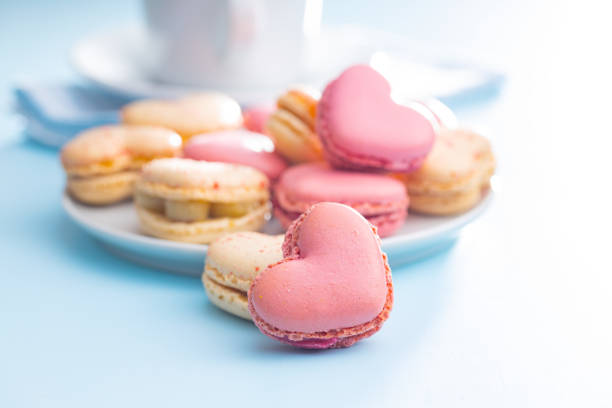 istock Heart shaped Sweet macarons on blue table. 1400060462