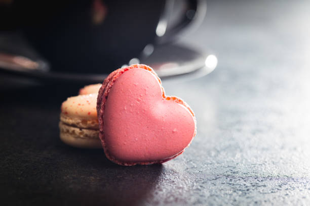 istock Heart shaped Sweet macarons on black table. 1400060509