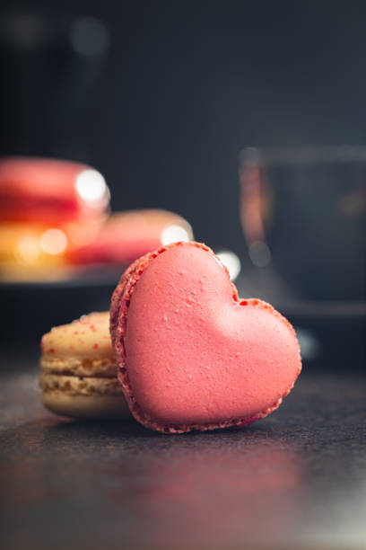 istock Heart shaped Sweet macarons on black table. 1400060511