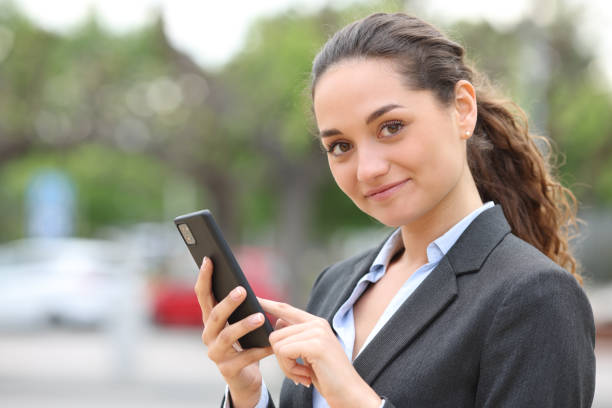 istock Confident executive holding phone and looking at camera 1400061182