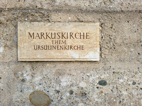 Close-up of the sign outside the Church of St Marcus on the West bank of the river in Salzburg.