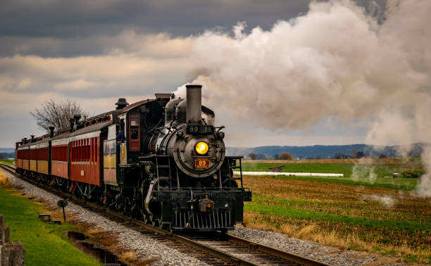 istock Antique Restored Steam Engine and Coaches Approach Blowing Smoke 1400062109