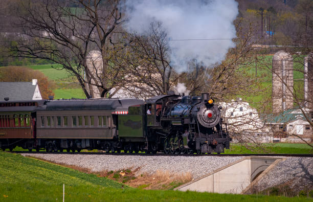 istock Antique Steam Passenger Train Approaching on a Single Track Blowing Smoke 1400062165
