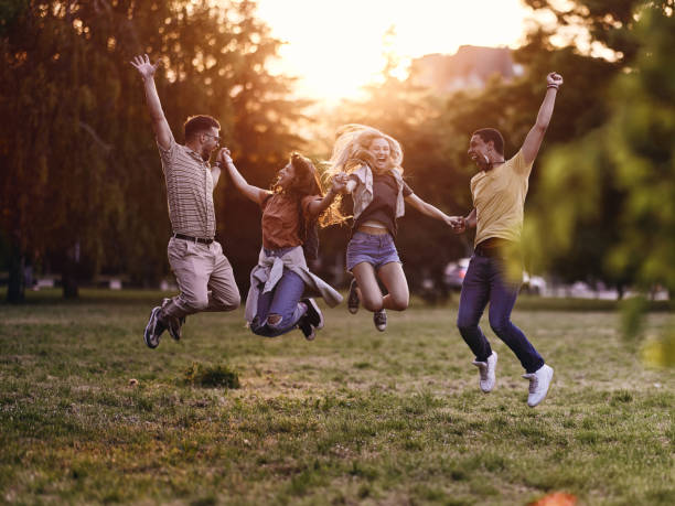 istock Carefree friends having fun while jumping in nature at sunset. 1400064246