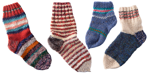 Set of different knitting socks from woolen threads. Handmade cozy homemade warm winter colorful striped knitted socks.