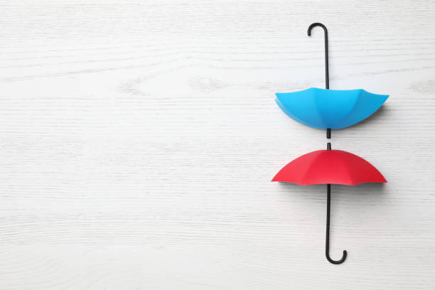 istock Small color umbrellas on white wooden background, flat lay. Space for text 1400065088