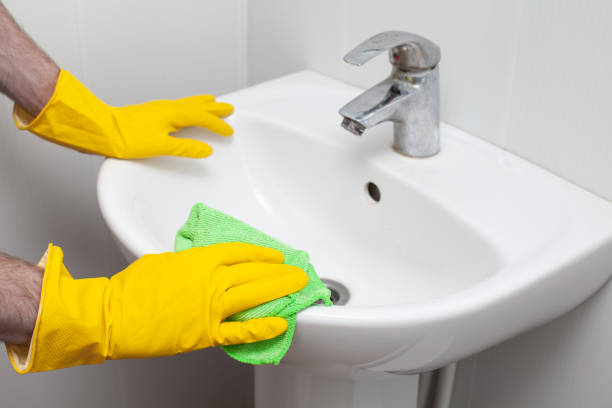 istock Rubber gloved hand cleaning sink with duster 1400065438