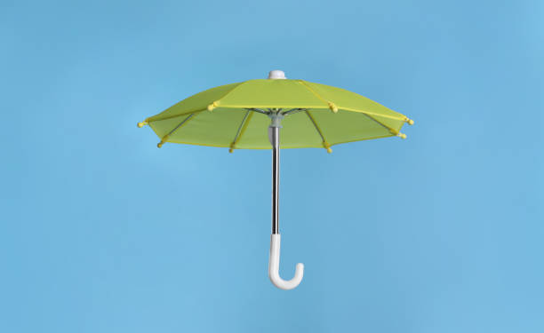 istock Open small yellow umbrella on light blue background 1400065588