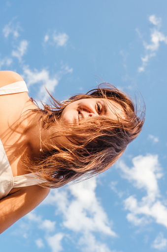 Young woman having fun outdoor. Bottom view. Sky background.