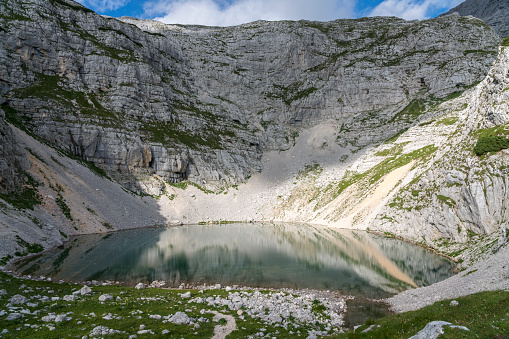 Lower Krisko Lake (Spodnje Kriško jezero) in the heart of mountain peaks at Kriški Podi,  Triglav national park, Julian Alps