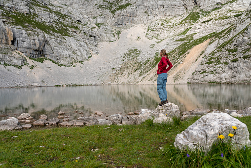 Women hiking at Lower Krisko Lake (Spodnje Kriško jezero) in the heart of mountain peaks in Triglav national park, Julian Alps