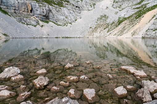 Lower Krisko Lake (Spodnje Kriško jezero) in the heart of mountain peaks at Kriški Podi,  Triglav national park, Julian Alps