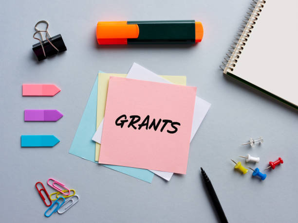 The word grants written on a notepaper on business office desktop. Funding or financial support in education or business. The word grants written on a notepaper on business office desktop. Funding or financial support in education or business. giving stock pictures, royalty-free photos & images