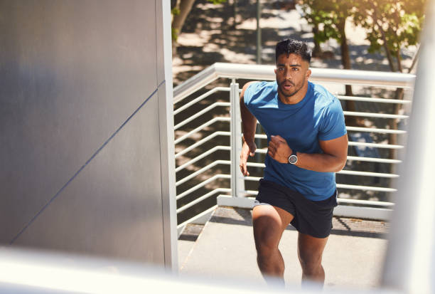 istock Handsome mixed race athletic man running up the steps on of a building while focused on his fitness. Hispanic male serious about his health while doing cardio and working on his speed and energy. 1400070335