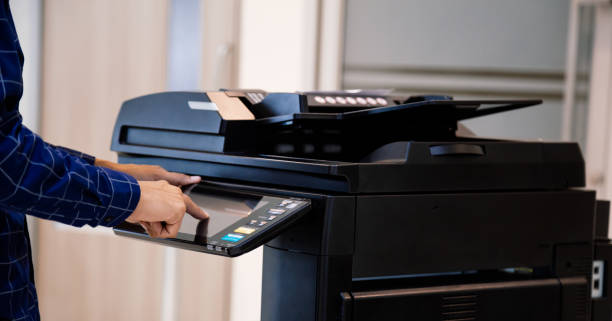 istock Businessmen press button on the panel for using photocopier or printer for printout and scanning document paper at office. 1400070461