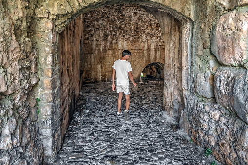 A man enters an ancient arched tunnel in Rozafa Castle, Albania