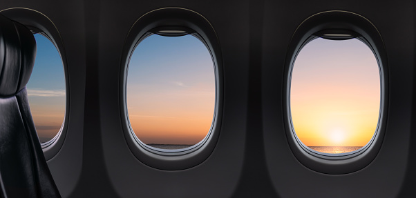 Empty seat inside airplane and window view  sunset sky on flight