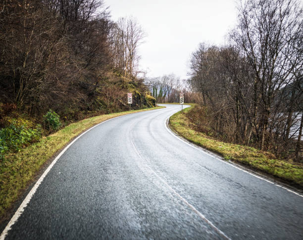 An S bend on a winding country road in the Scottish Highlands, with warning signs that a 40mph speed limit is approaching.