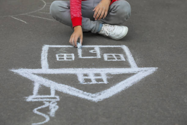 istock Child drawing house with chalk on asphalt, closeup 1400071978
