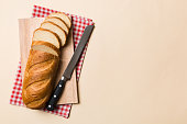 Freshly baked bread cut with knife on a wooden board. top view Sliced bread and knife