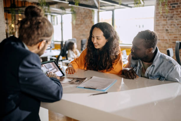 istock Casually clothed tattooed architect on a meeting with young married couple 1400073781