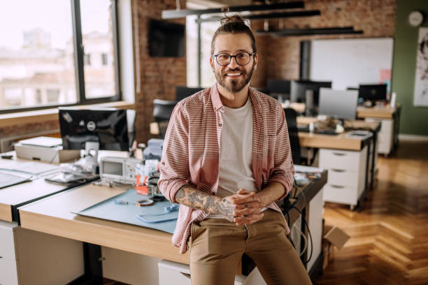 istock Handsome young tattooed businessman posing in the office 1400075101