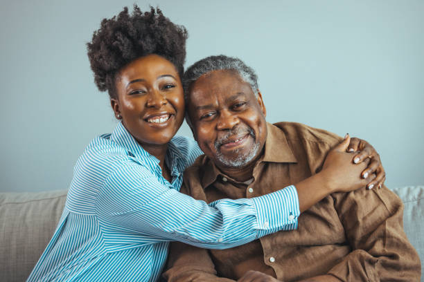 istock Loving senior man embracing his daughter while sitting on sofa smiling 1400075322