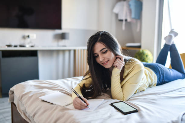 istock Cute Female Completing Homework At Home 1400075724