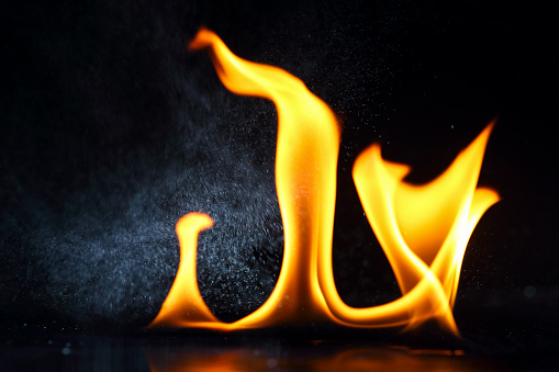 Fire and water. Spraying small droplets of water onto a burning fire.