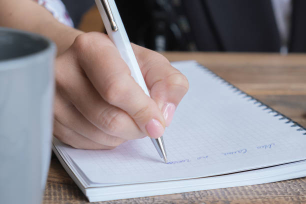 istock Close-up of female hands with pen and notepad 1400077951
