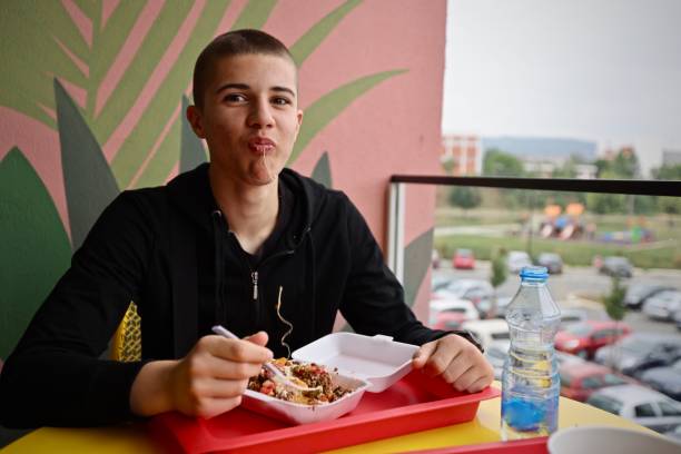 Kid with full mouth of food loking directly in the camera with messy mouth