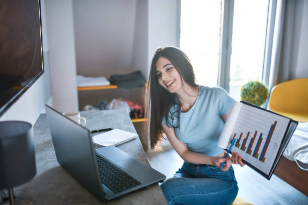 istock Smiling Female Student Showing Economy Analysis On Camera During Online Lesson 1400081809