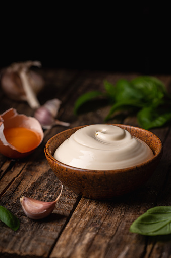 Bowl of Homemade mayonnaise sauce with ingredients and herbs for cooking