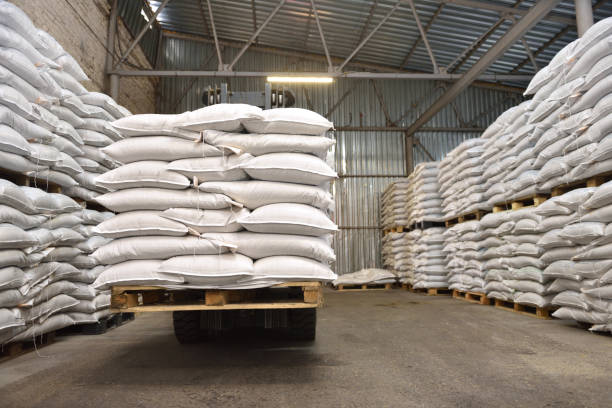 White stacked sacks of wheat in a warehouse stock photo