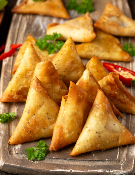 istock Fried samosas with vegetable filling, popular Indian snacks on wooden board 1400083465
