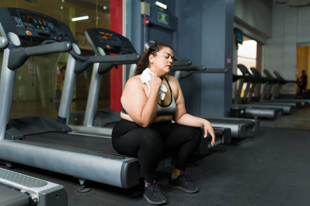 Exhausted obese woman working out stock photo