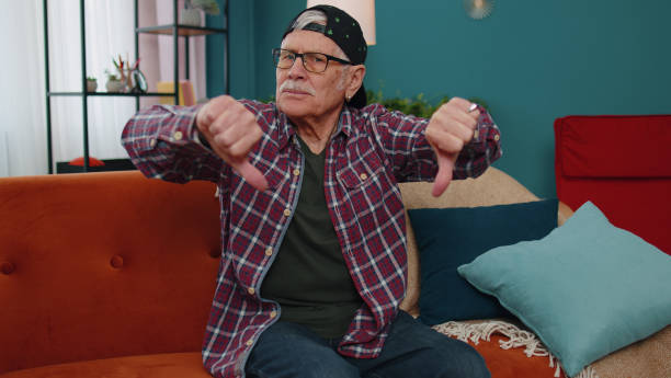 istock Senior man showing thumbs down sign gesture expressing discontent, disapproval, dissatisfied dislike 1400085608