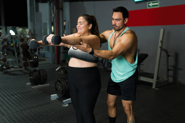 istock Exhausted fat woman doing weight training 1400086897