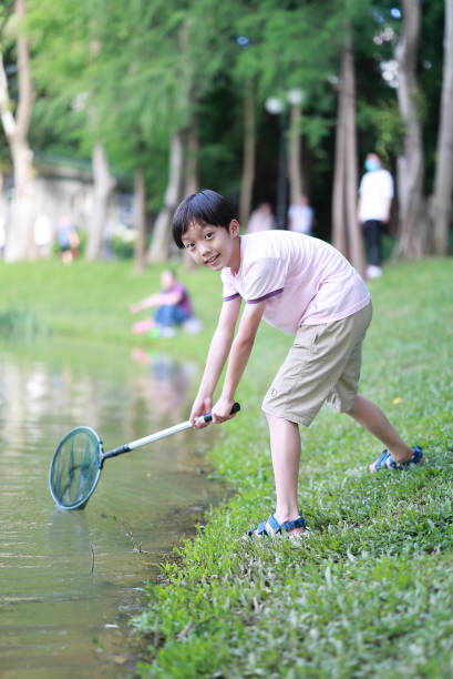 istock boy by a river with a fishing net 1400087174