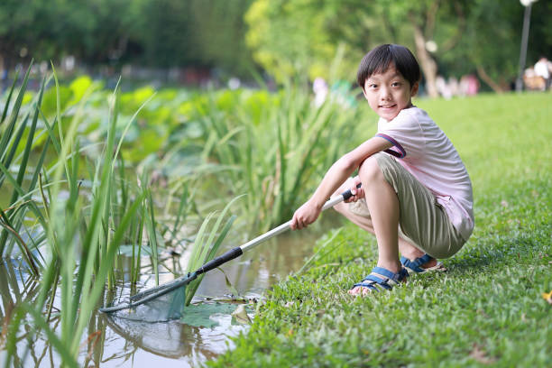 istock boy by a river with a fishing net 1400087208